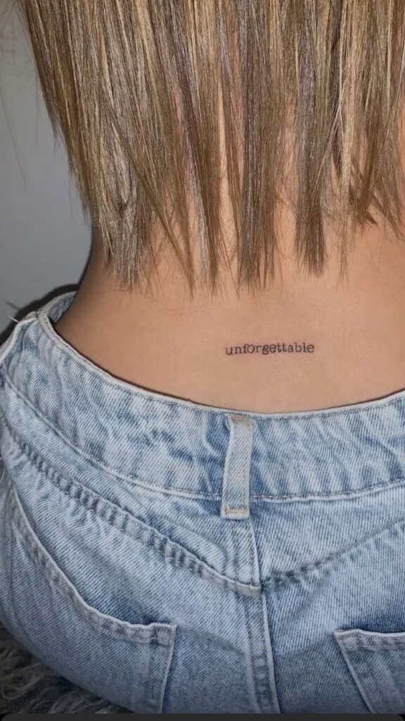 Lower back minimalist statement text tattoo