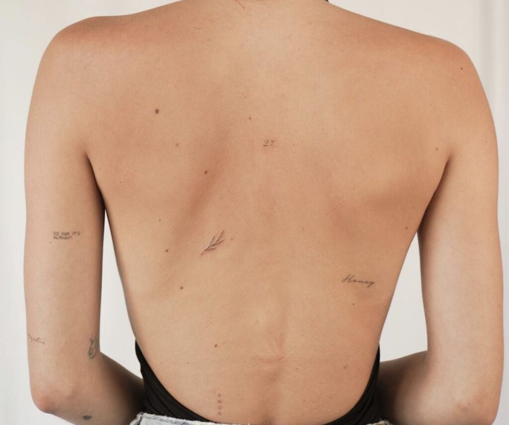 scattered tiny tattoos on back