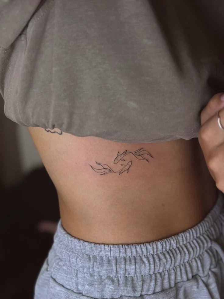 feminine minimalist koi fish tattoo
